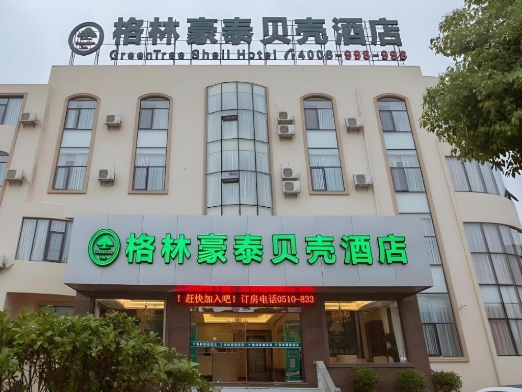 GreenTree Inn Wuxi Donggang Town Donghutang Shell Hotel في ووشي: مبنى به لافتة على واجهته