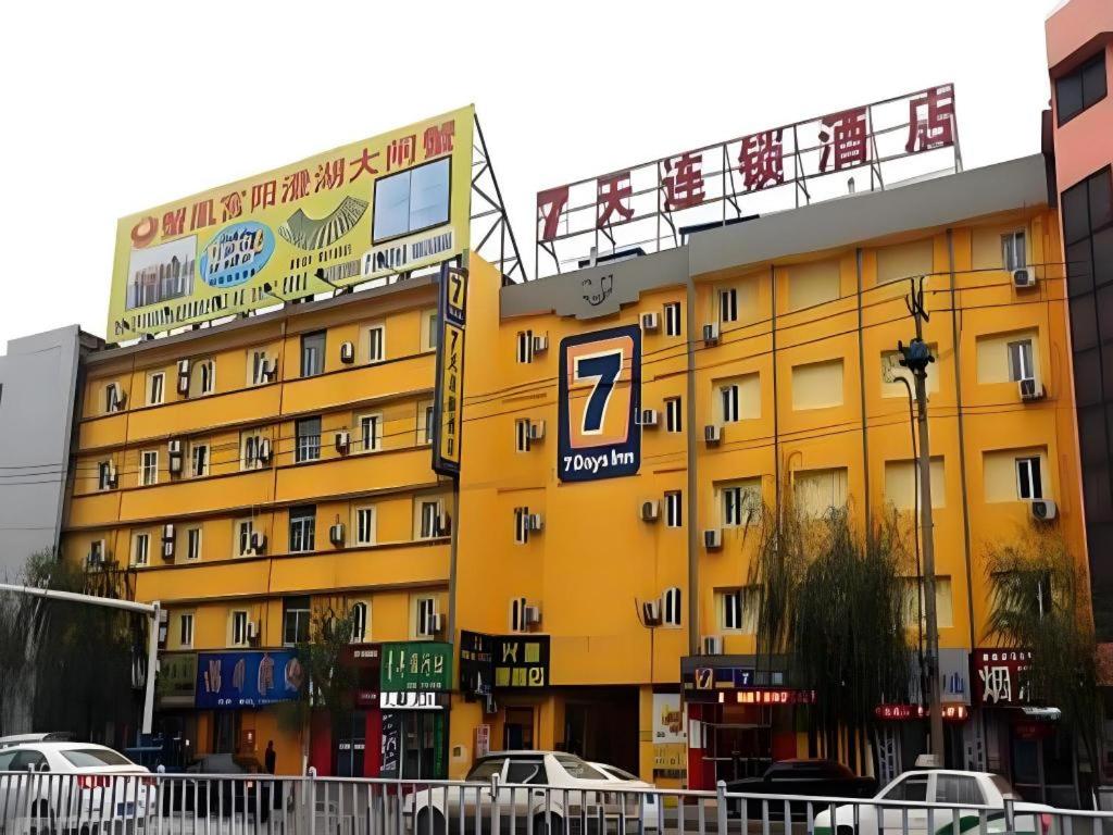 a yellow building with a parking sign on it at 7 Days Inn Siping Xinhua Street in Siping