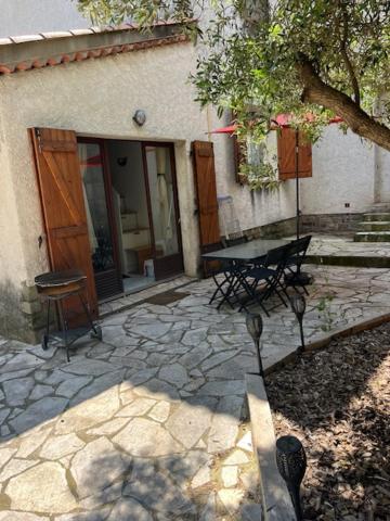 a patio with a table and chairs in front of a building at Studio meublé Fréjus équipé d'une climatisation in Fréjus