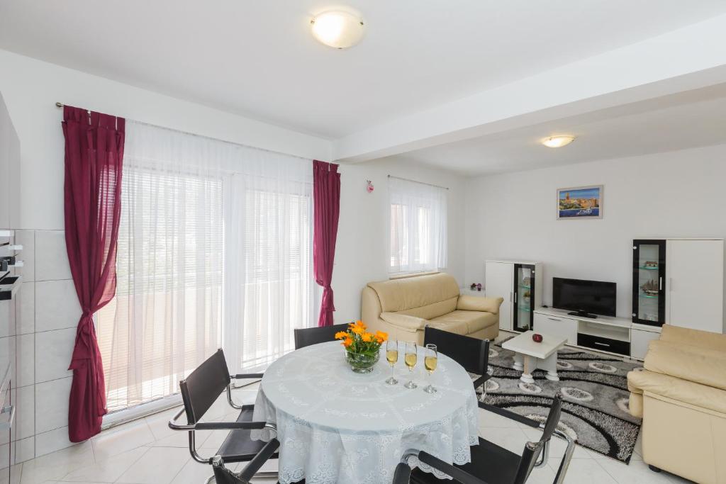 un soggiorno con tavolo e sedie bianchi di Apartment Anna a Kaštela (Castelli)