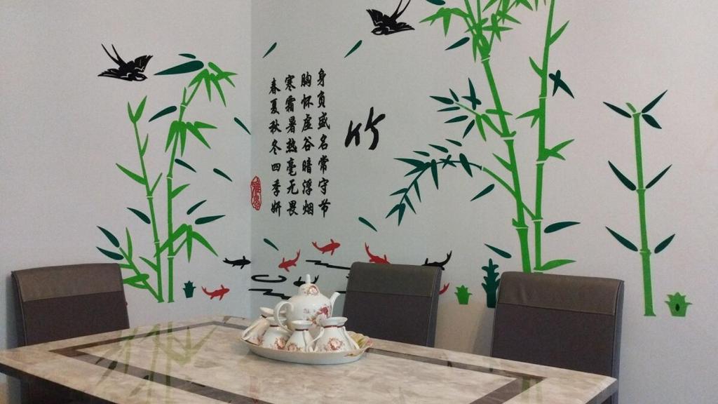 a dining room table with a wall with bamboo and birds at 2Op Ipoh, Semi D, in Ipoh