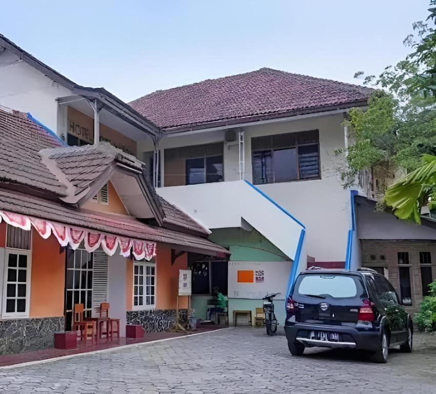 a car parked in front of a building at Hotel O Jahip Syariah in Bojong Dua