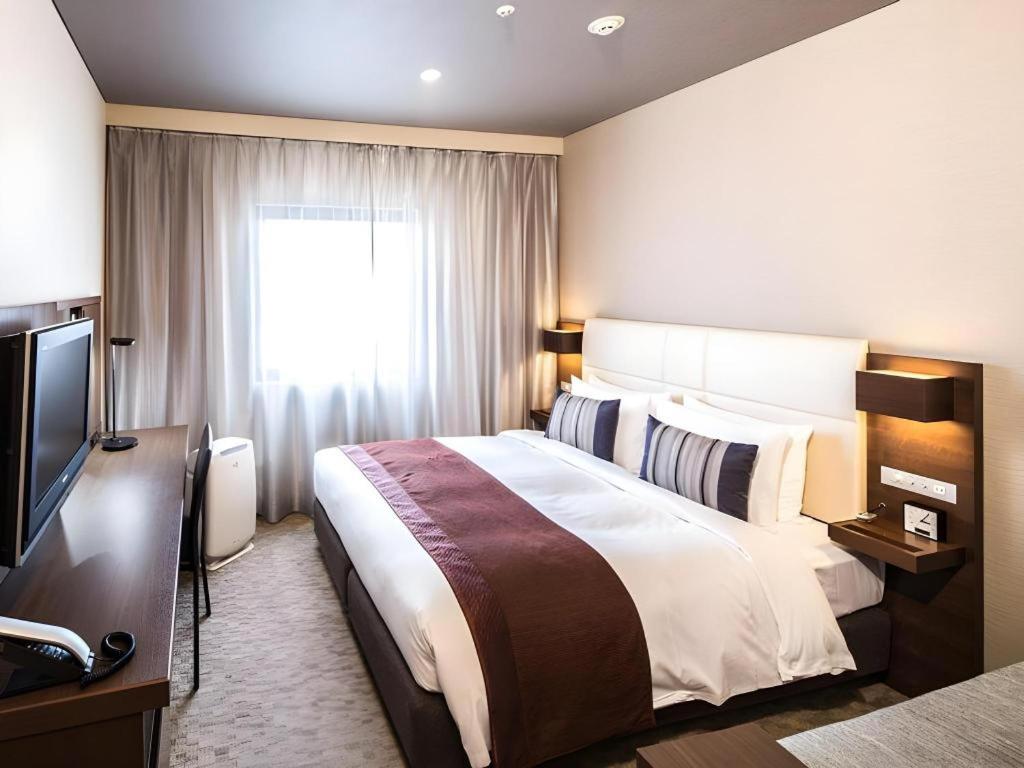 a hotel room with a bed and a television at Nagoya Sakae Tokyu REI Hotel in Nagoya