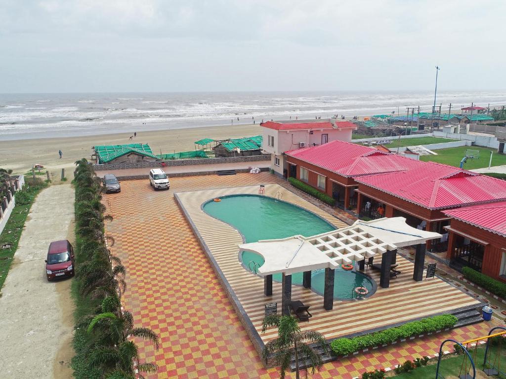 un complexe avec une piscine à côté de la plage dans l'établissement Prasant Beach Resort Mandarmani, à Mandarmoni