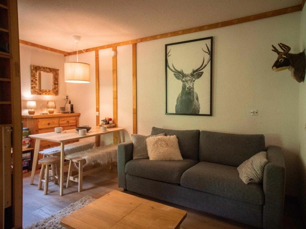 a living room with a couch and a table at Studio-cabine au pied des pistes avec terrasse de plain-pied in Valmorel