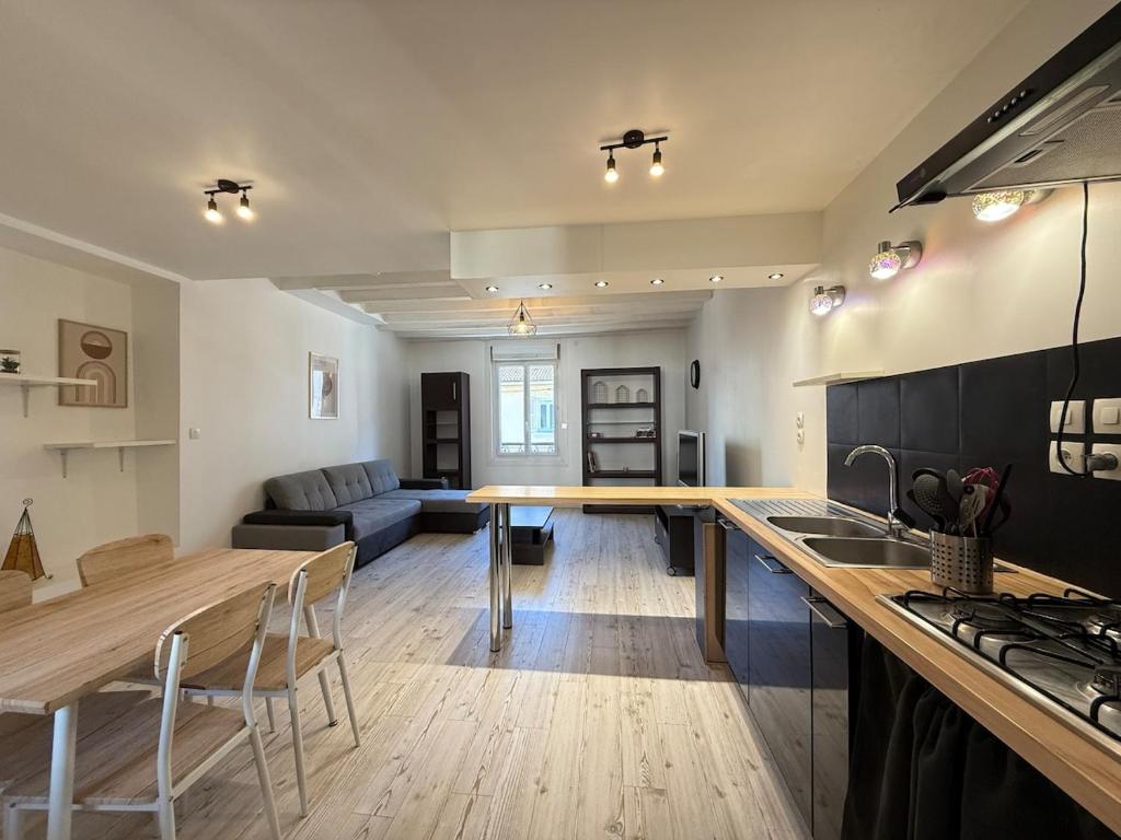 a kitchen and living room with a table and a couch at Calme et confort tout équipé au cœur de Moirans in Moirans