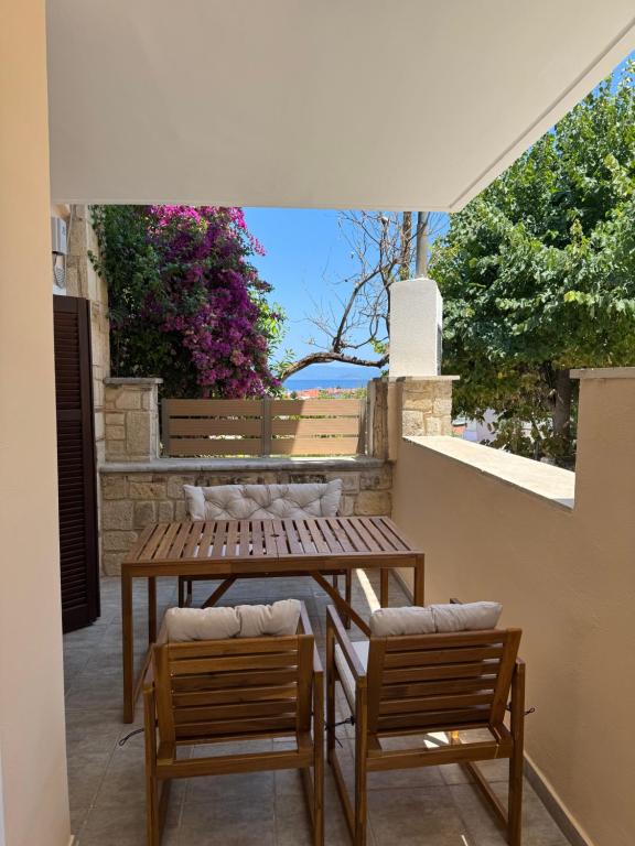 a patio with two benches and a table and chairs at Το Πέτρινο Σπιτι in Polykhrono