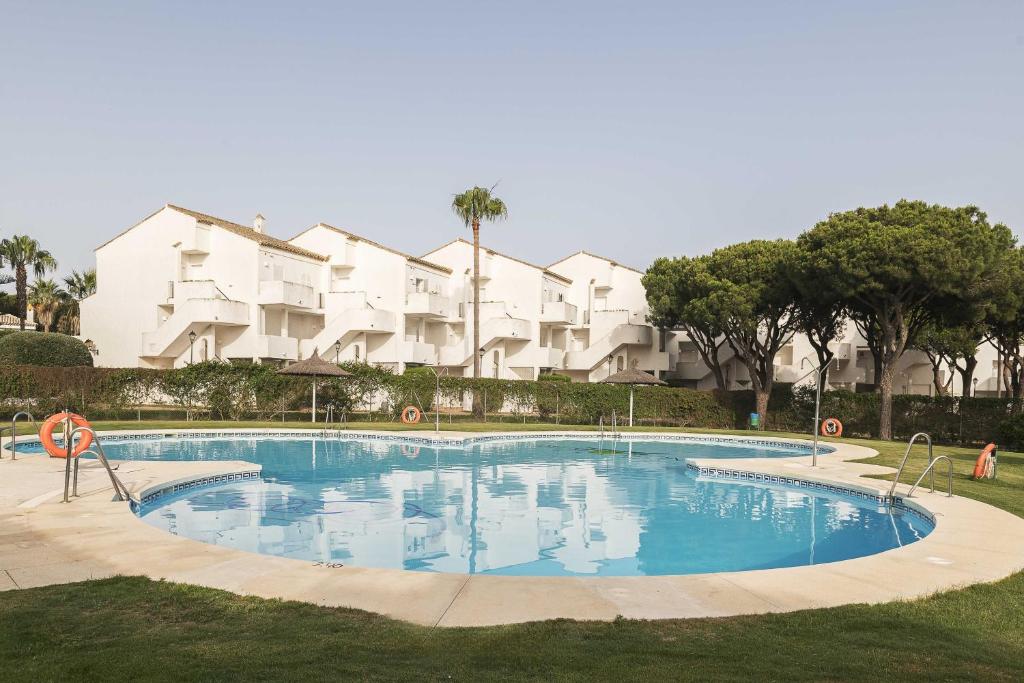 una gran piscina frente a un edificio en Estribor, en Poblado de Sancti Petri