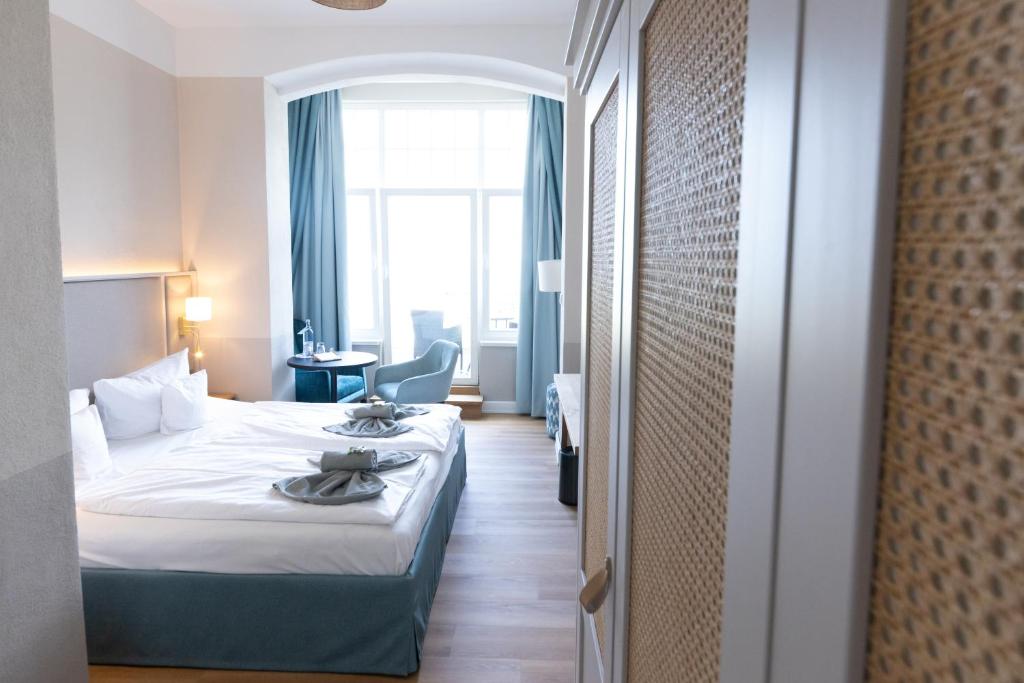 a hotel room with a bed and a window at Hotel Germania in Bansin