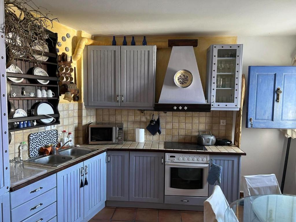 una cocina con fregadero y estufa horno superior en Serifos house, en Serifos Chora
