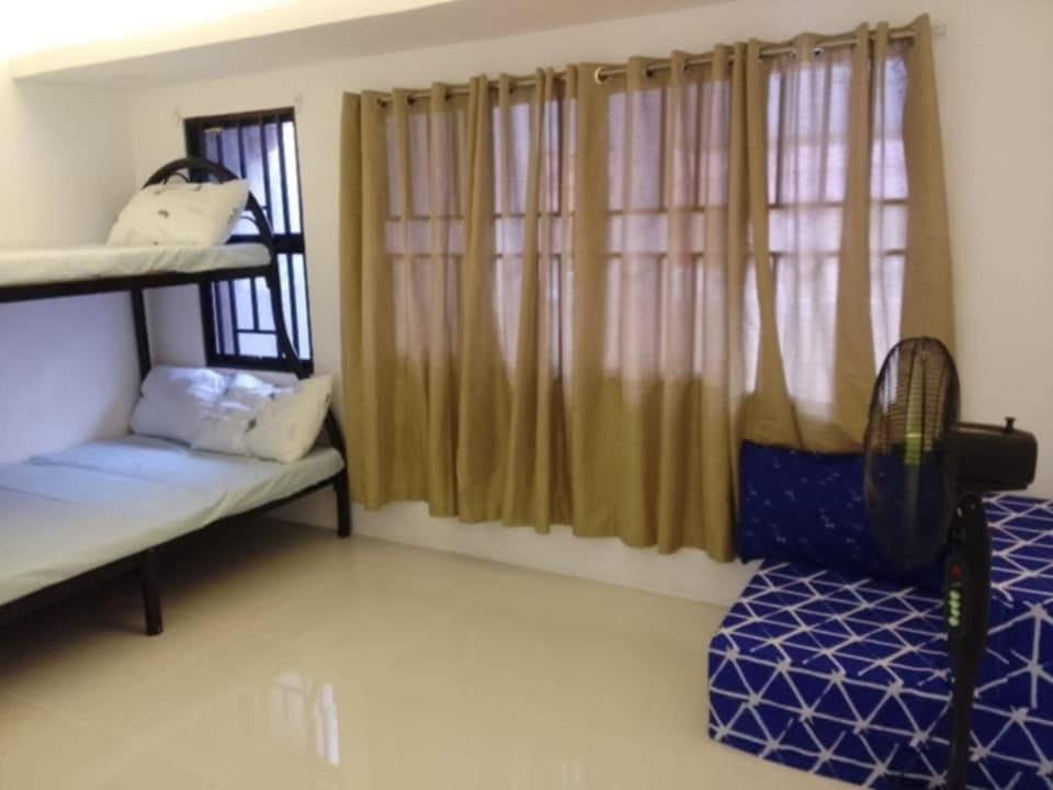 a room with two bunk beds and a window at JKVacation Home in Tacondo
