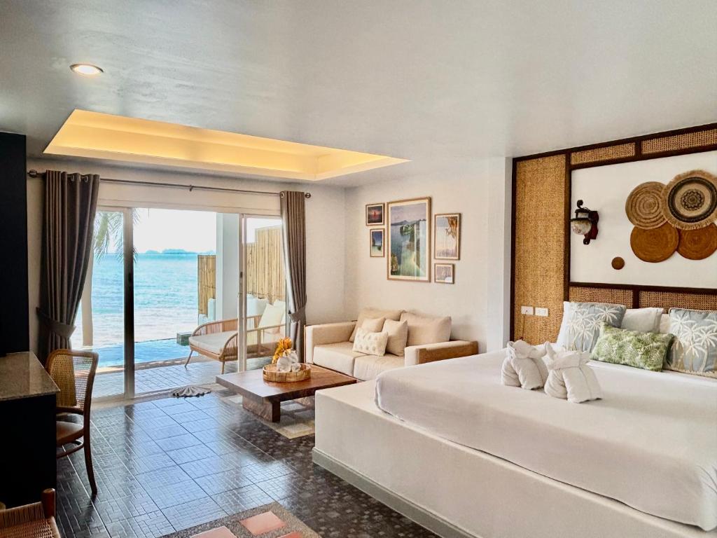 a bedroom with a large bed and a living room at Arawan Beach Resort Krabi in Ao Nam Mao