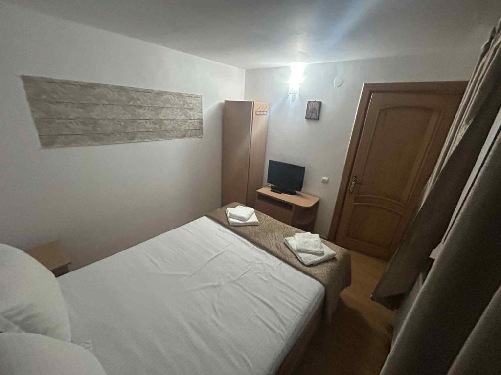 a small bedroom with a bed and a television at Vila Robert in Slănic-Moldova