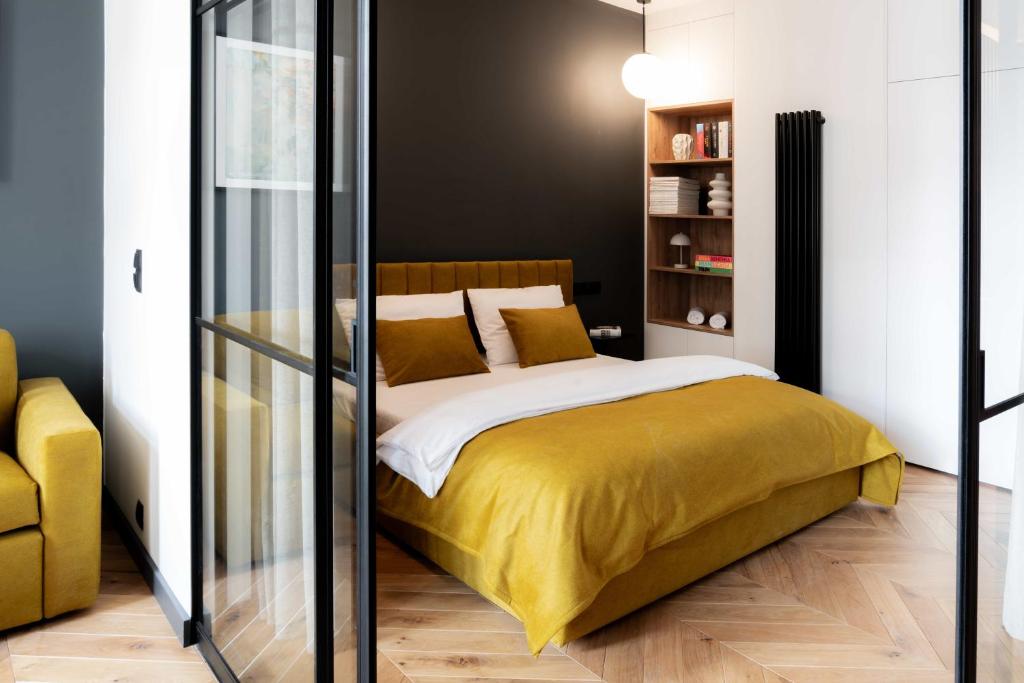 a bedroom with a bed with a yellow blanket at Grodzka Stare Miasto Aparthotel - Dream Apart in Jelenia Góra