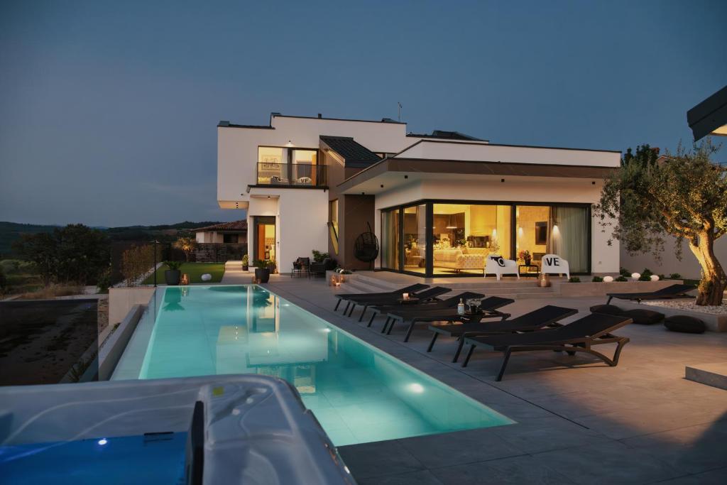 a house with a swimming pool in front of a house at Villa KIM in Momjan