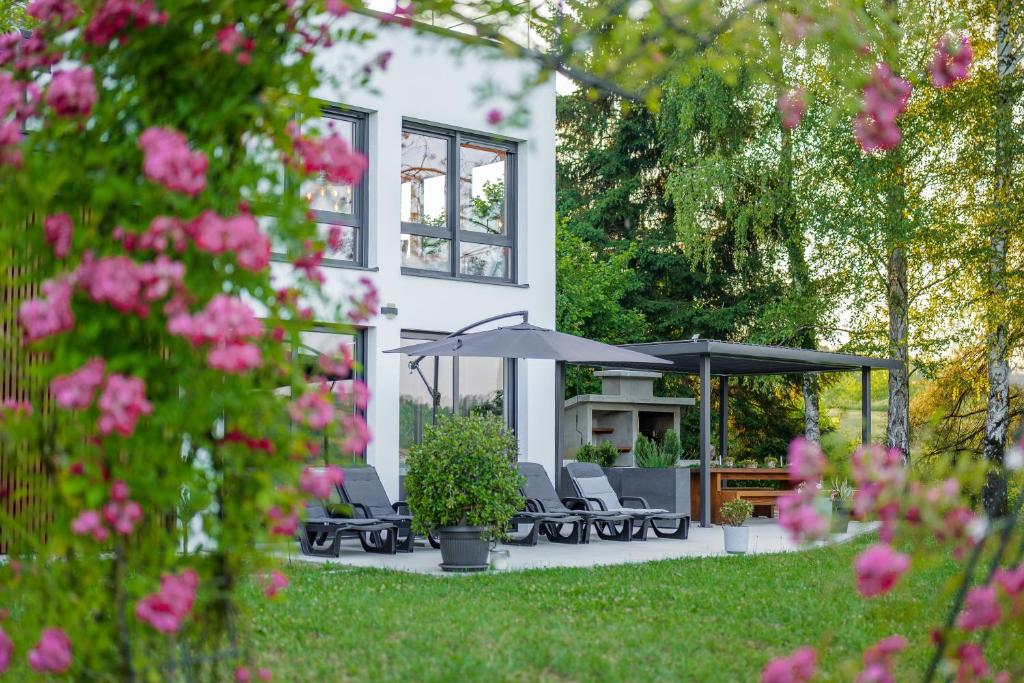 a house with chairs and umbrellas in the yard at Kuća za odmor Šumska Vila in Duga Resa