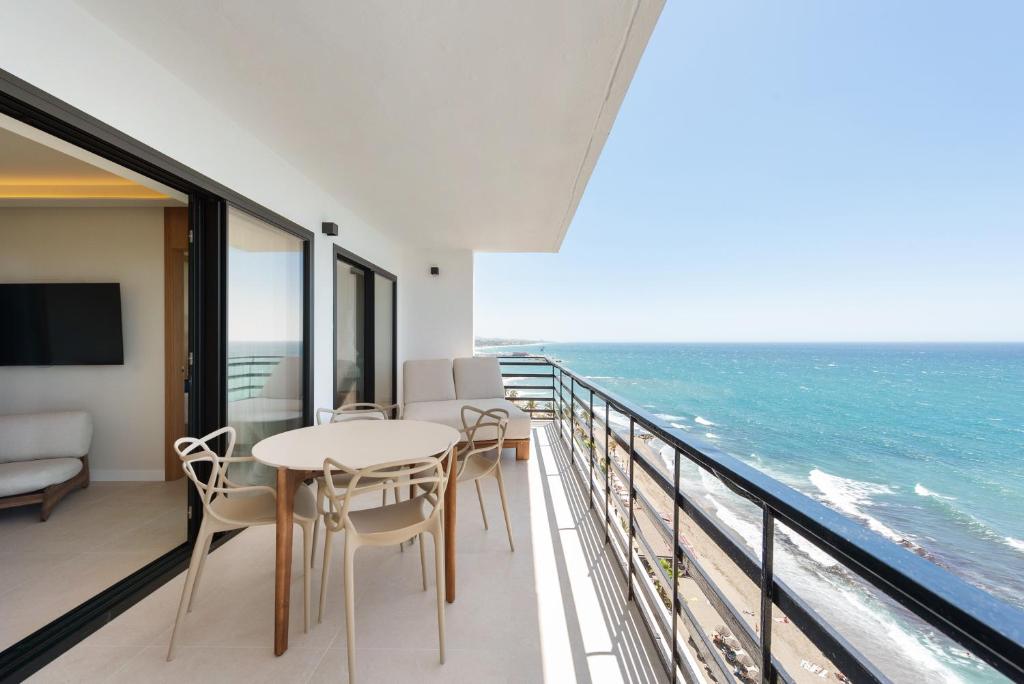 a balcony with a table and chairs and the ocean at Arlequin Suites in Marbella