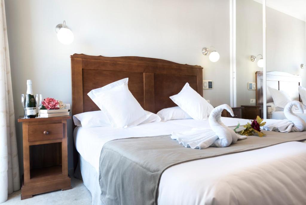 two beds in a hotel room with two swans on them at Hotel Toboso Chaparil in Nerja