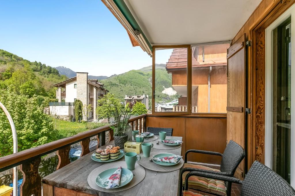 a table with plates of food on a balcony at Boutique Apartment Limone Ski In Ski Out - Happy Rentals in Limone Piemonte