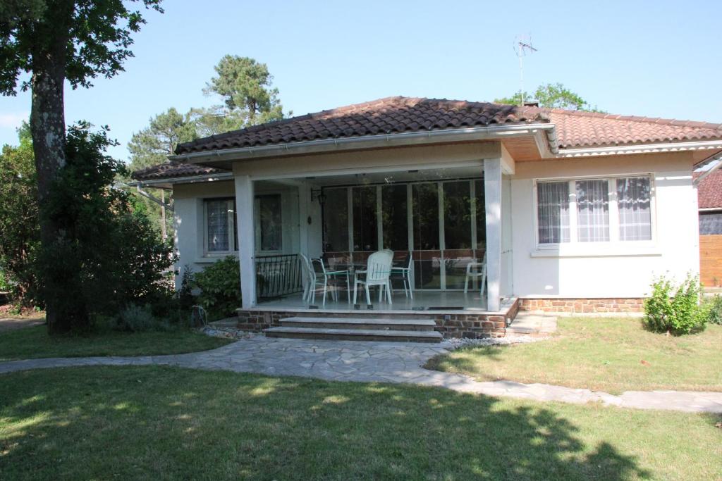 une petite maison blanche avec une terrasse couverte et des chaises dans l'établissement Maison entière 3 chambres, à Saint-Brévin-les-Pins