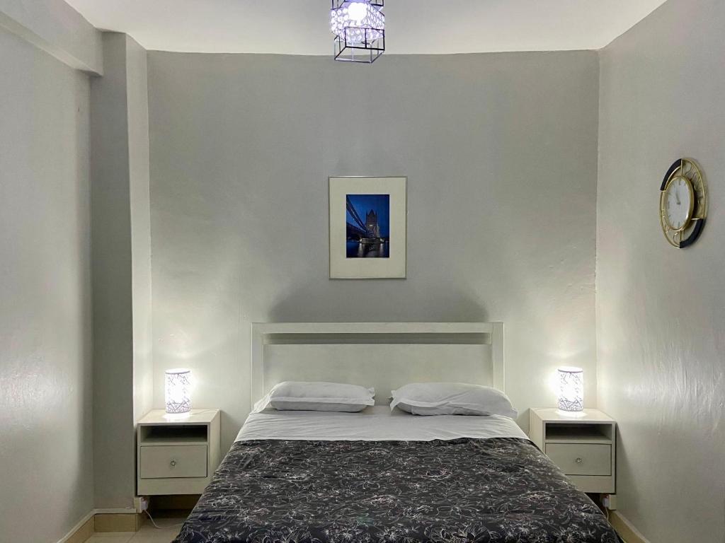 カンパラにあるKampala city center vin havenのベッドルーム1室(ナイトスタンド2つ、ランプ2つ付)