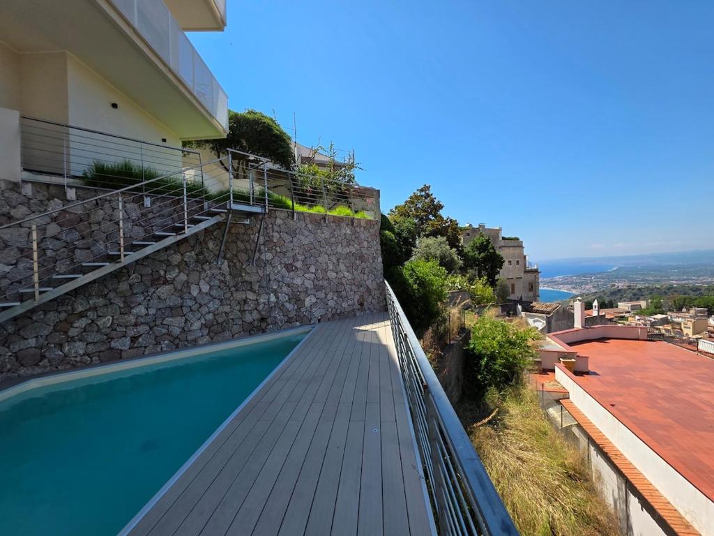a balcony with a swimming pool next to a building at Casa DiMa - La Pigna Verde in Taormina