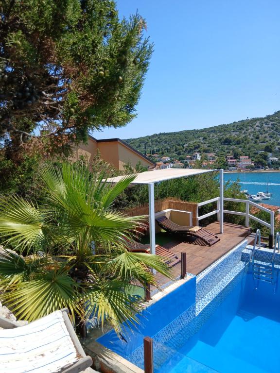 een resort met een zwembad en uitzicht op de oceaan bij Apartmenthaus Kornatiblick in Tisno