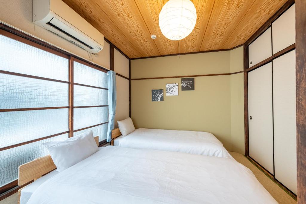 due letti in una stanza con due finestre di Higashi-Ueno 3 a Tokyo