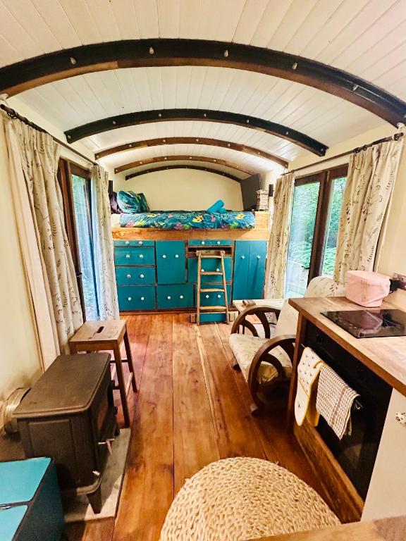 a living room with a table and a bed in a room at The Railway Carriage - Blue in Glasbury
