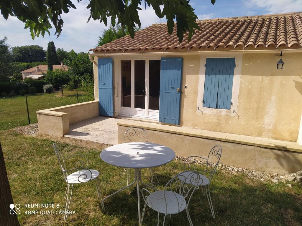a table and chairs in front of a house at Domaine Guiton Cerise noire in Chamaret