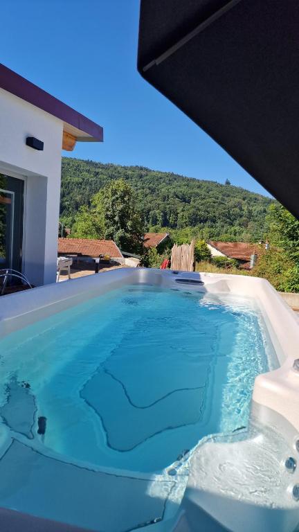 a large swimming pool with blue water in a house at Le Domaine de la Répandise in Laveline-du-Houx