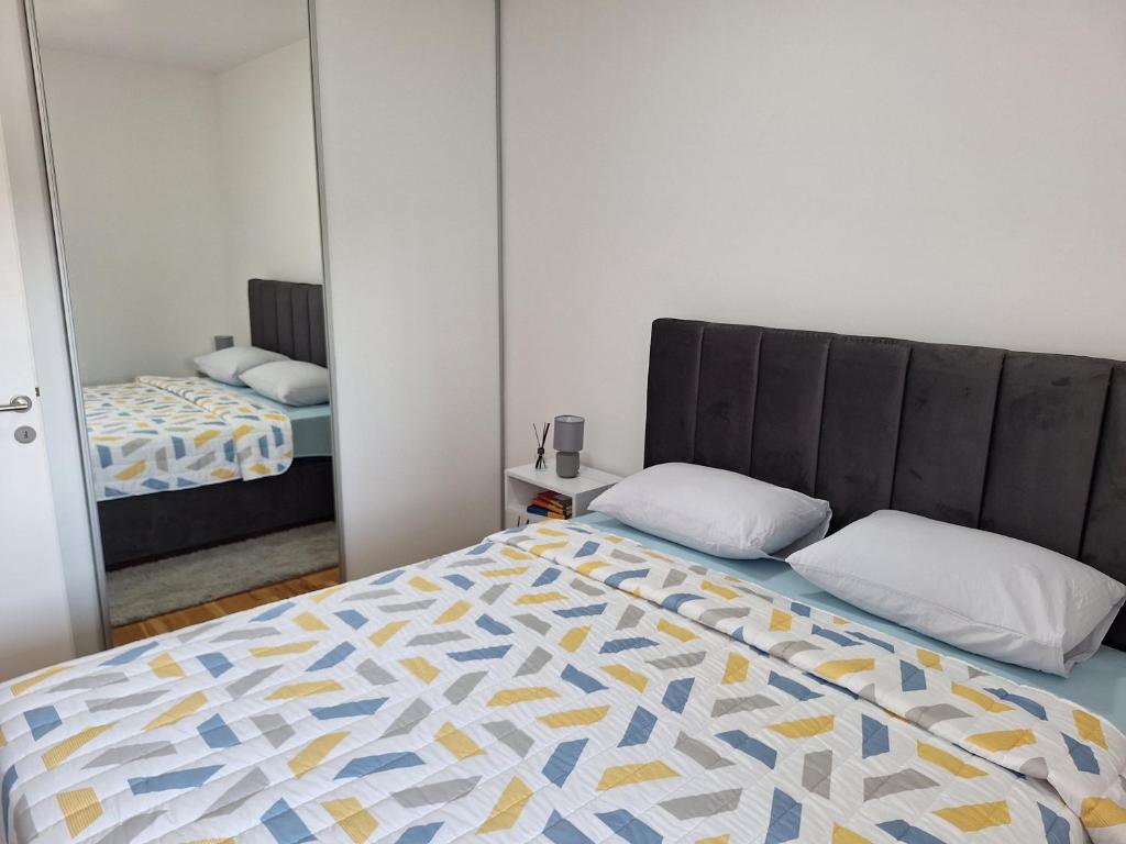 a bedroom with a bed and a mirror at Apartman Lory in Čapljina
