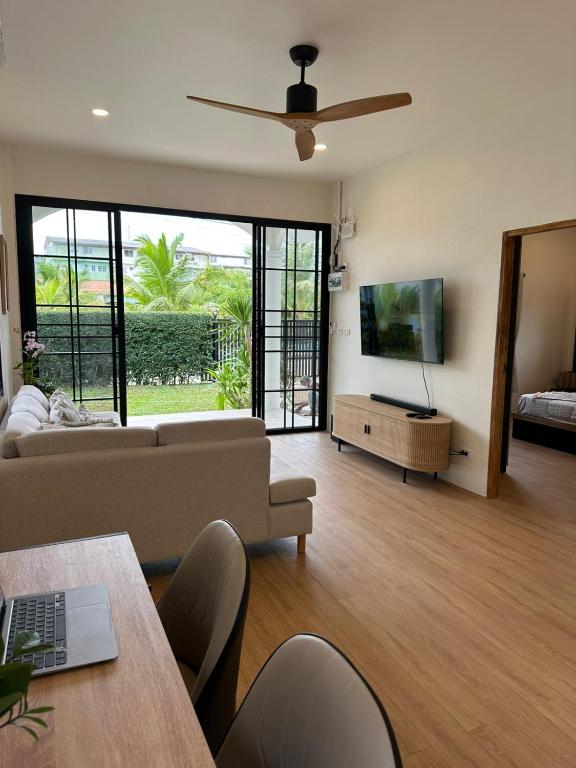 a living room with a couch and a flat screen tv at Chalong Home Phuket in Phuket