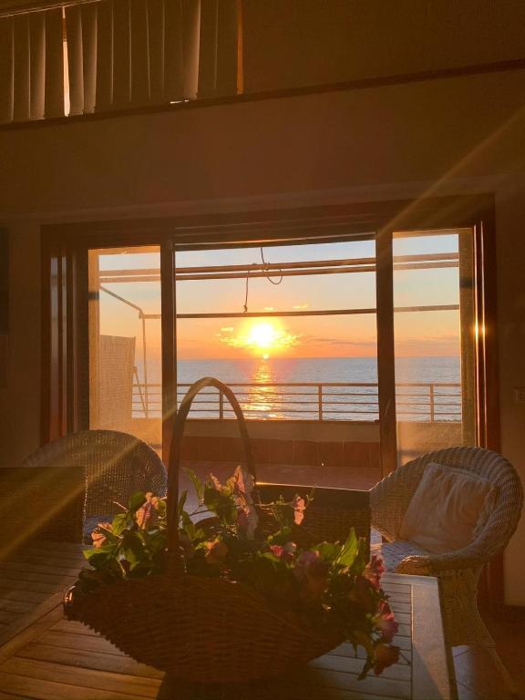 a table with a flower arrangement on it with a view of the ocean at Casa Stefania in Anzio