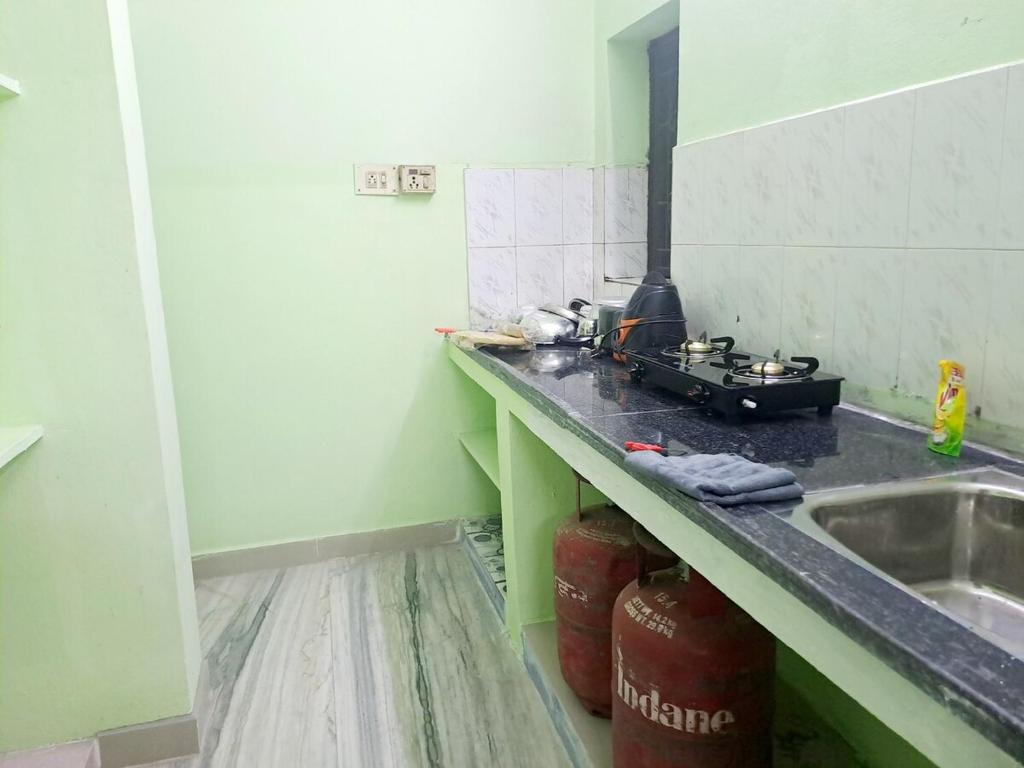 una cucina con piano di lavoro, lavandino e piano cottura di 10min Apollo Proton IITM DLF AirportF Entire house a Chennai