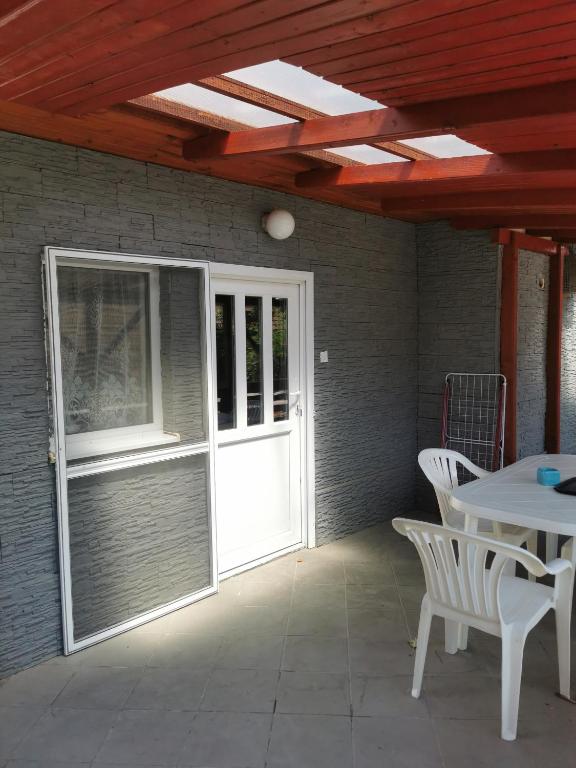 a patio with a door and a table and chairs at Szabadság vendéghaz in Tiszaújváros