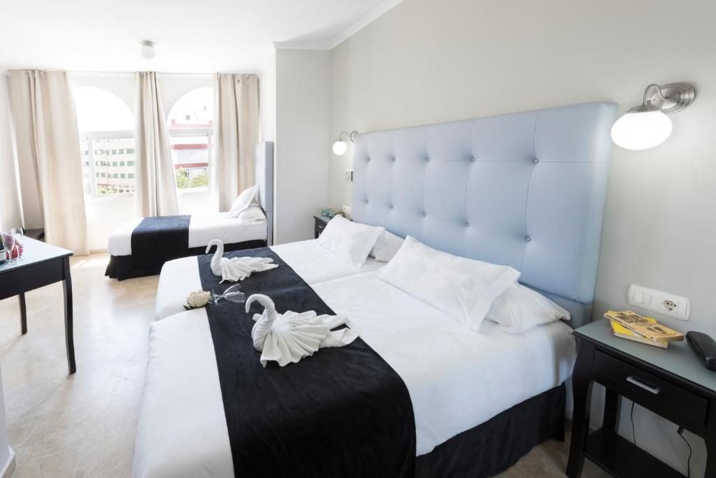 un dormitorio con una cama grande con cisnes. en Hotel Toboso Chaparil, en Nerja