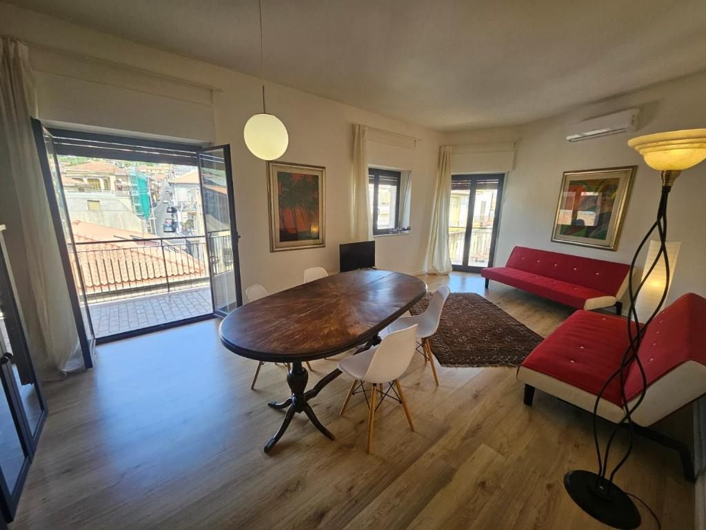 a living room with a wooden table and a red couch at Zafferana Etna House by Holiday World in Zafferana Etnea