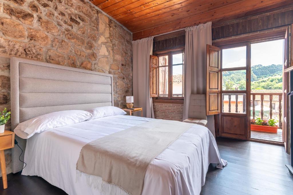 a bedroom with a bed and a stone wall at Casa La Franca in Ríocorvo