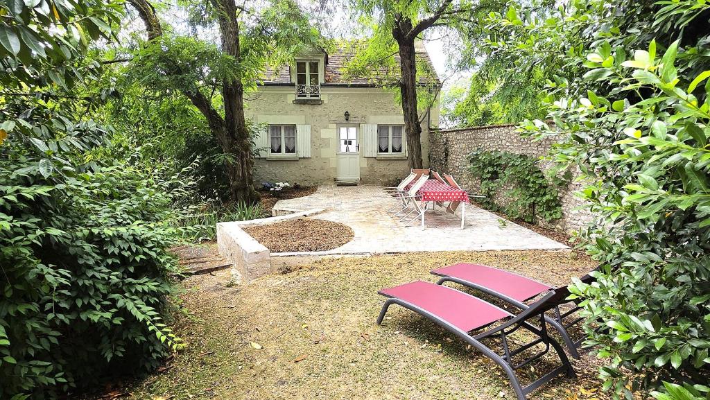 a garden with a bench and a table and a house at Bois logis in Bléré