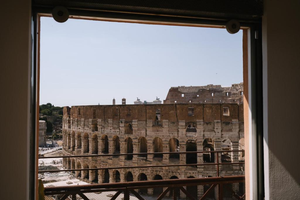 a view from a window of the coliseum at Colosseo Deluxe YH in Rome
