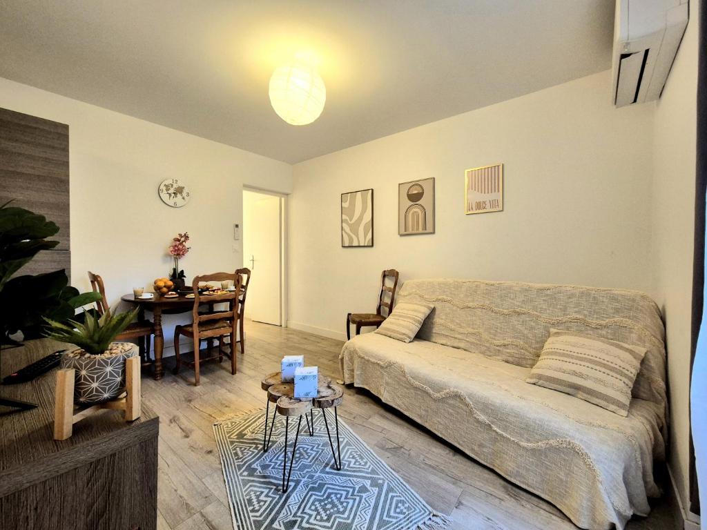 un salon avec un lit et une table dans l'établissement La patio - coeur de ville - clim, à Nîmes