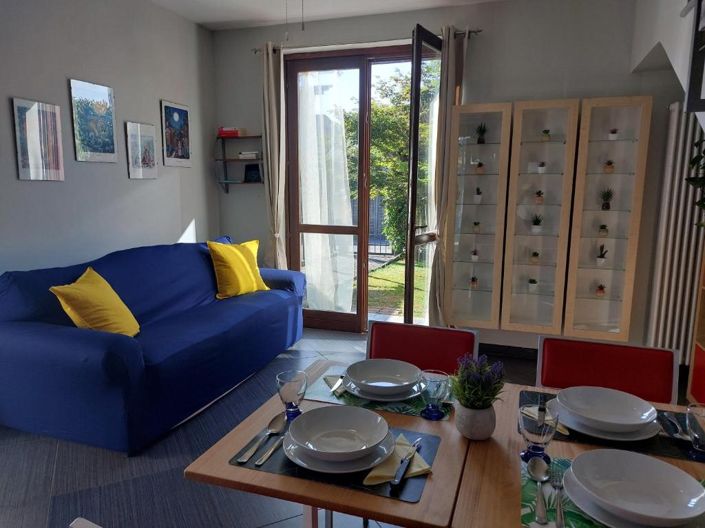 a living room with a blue couch and a table at Arona - Lake Maggiore Entire Home - parking in Arona