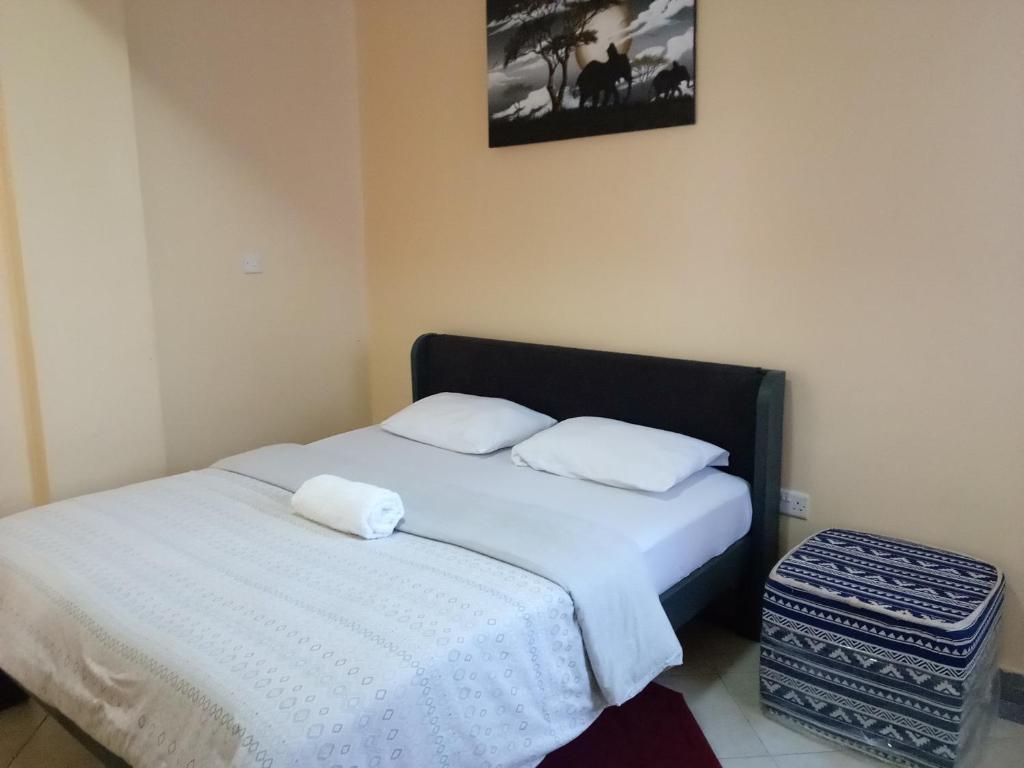 a bedroom with a bed with two white pillows at Ayo's Vacation Home in Thika