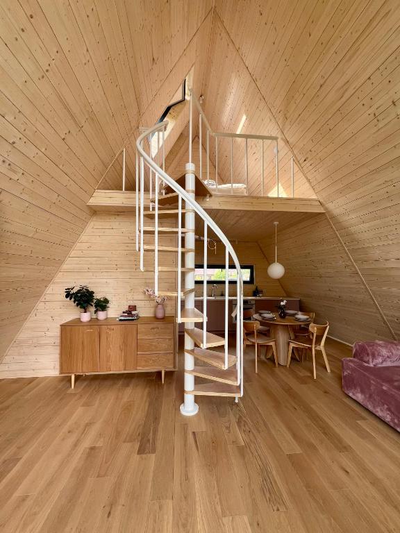 a room with a spiral staircase in a wooden ceiling at Jelenie Brdy in Brzegi Dolne