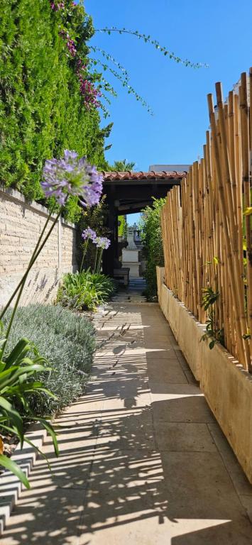 a garden path with a wooden fence and purple flowers at Villa Maria in Trani