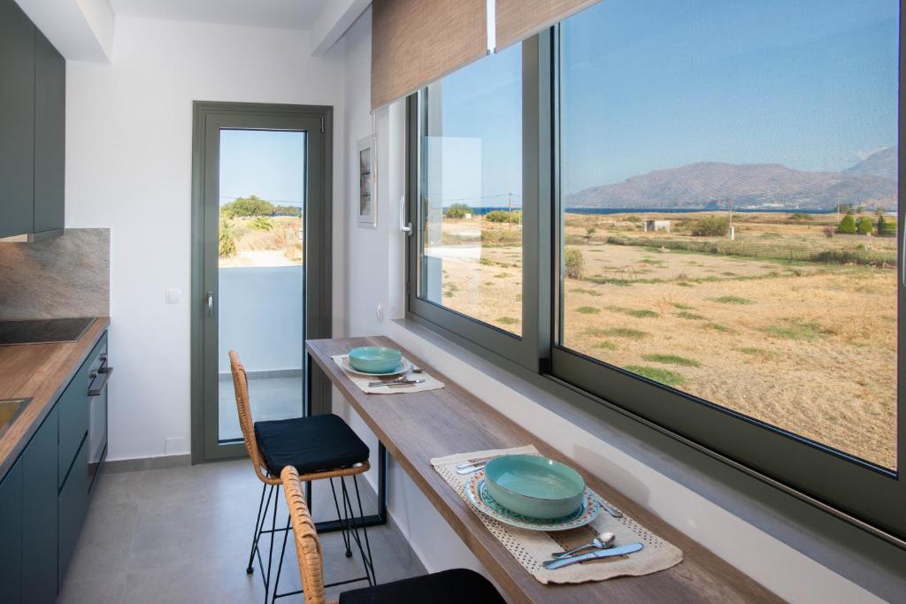 a kitchen with a table and a large window at Mediterranean Blue Suites & Villa - Blue Horizon Suite in Tympáki
