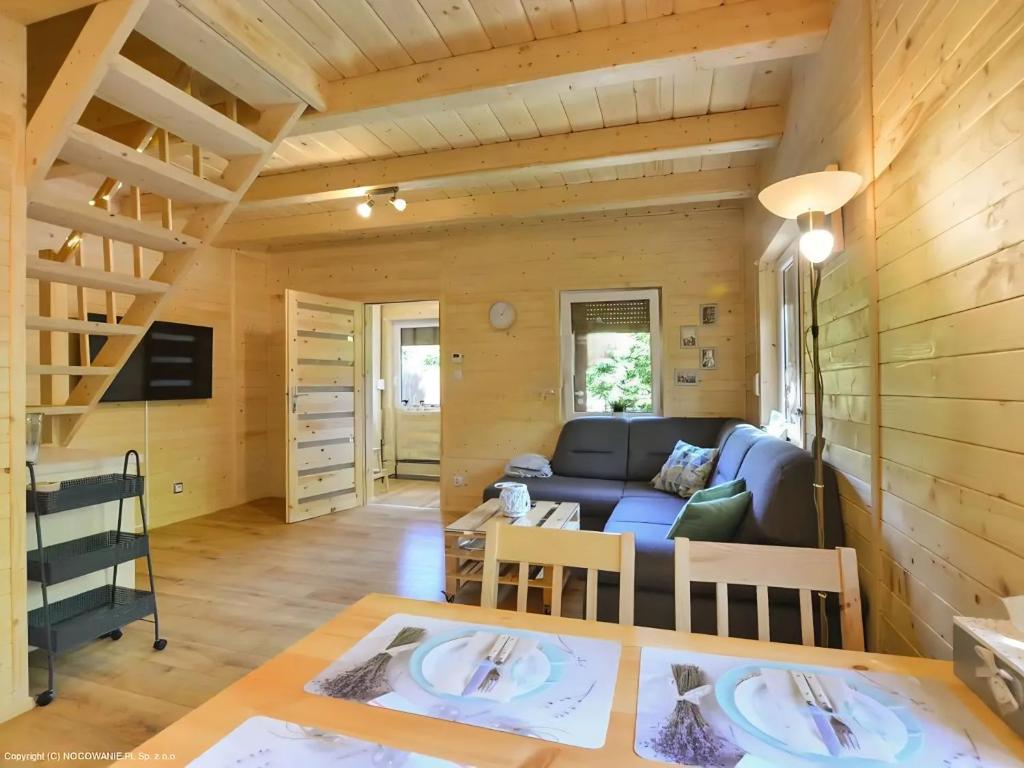 a living room with a blue couch and a table at Słoneczny Domek Radawa in Radawa