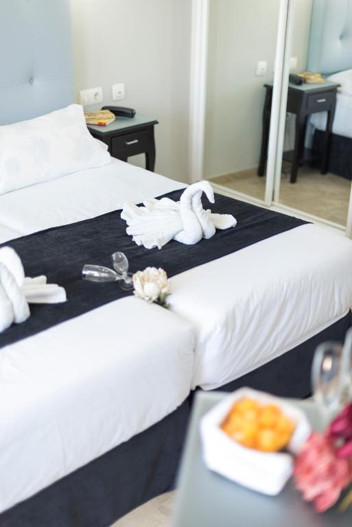 a hotel room with two beds and a tray of food at Hotel Toboso Chaparil in Nerja