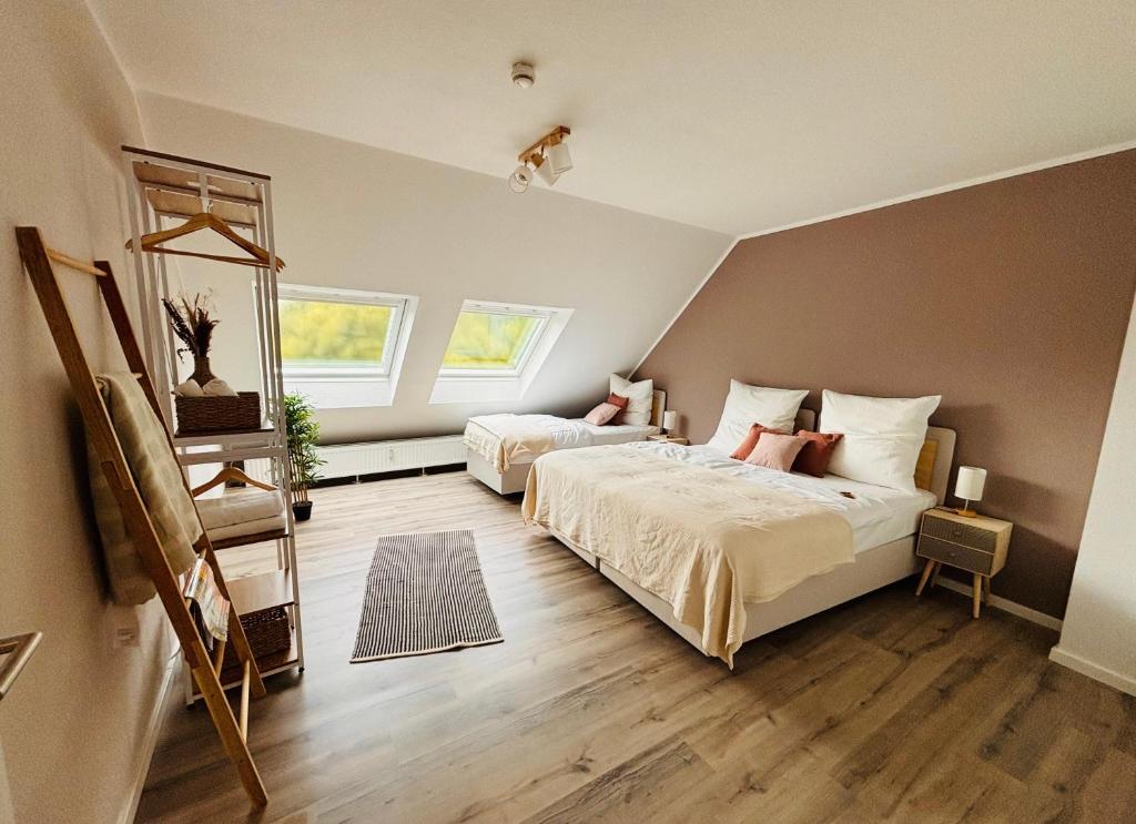 a bedroom with two beds and two windows at HYGGE HOMES - Apartment 'Urban Nest' - Schlossnähe trifft Design in Celle